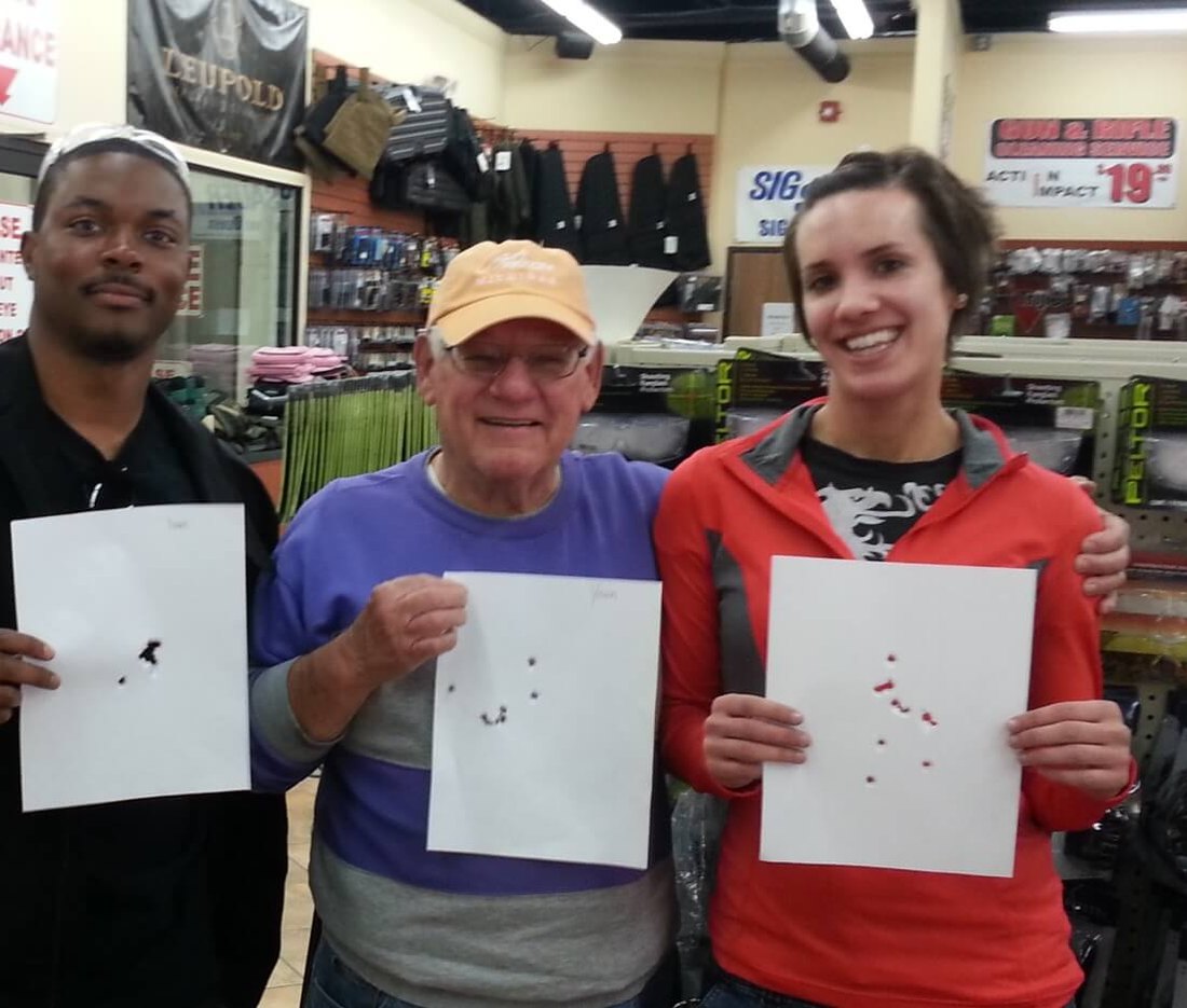Three Midwest Tactical Training students holding their range targets after a Michigan CPL class